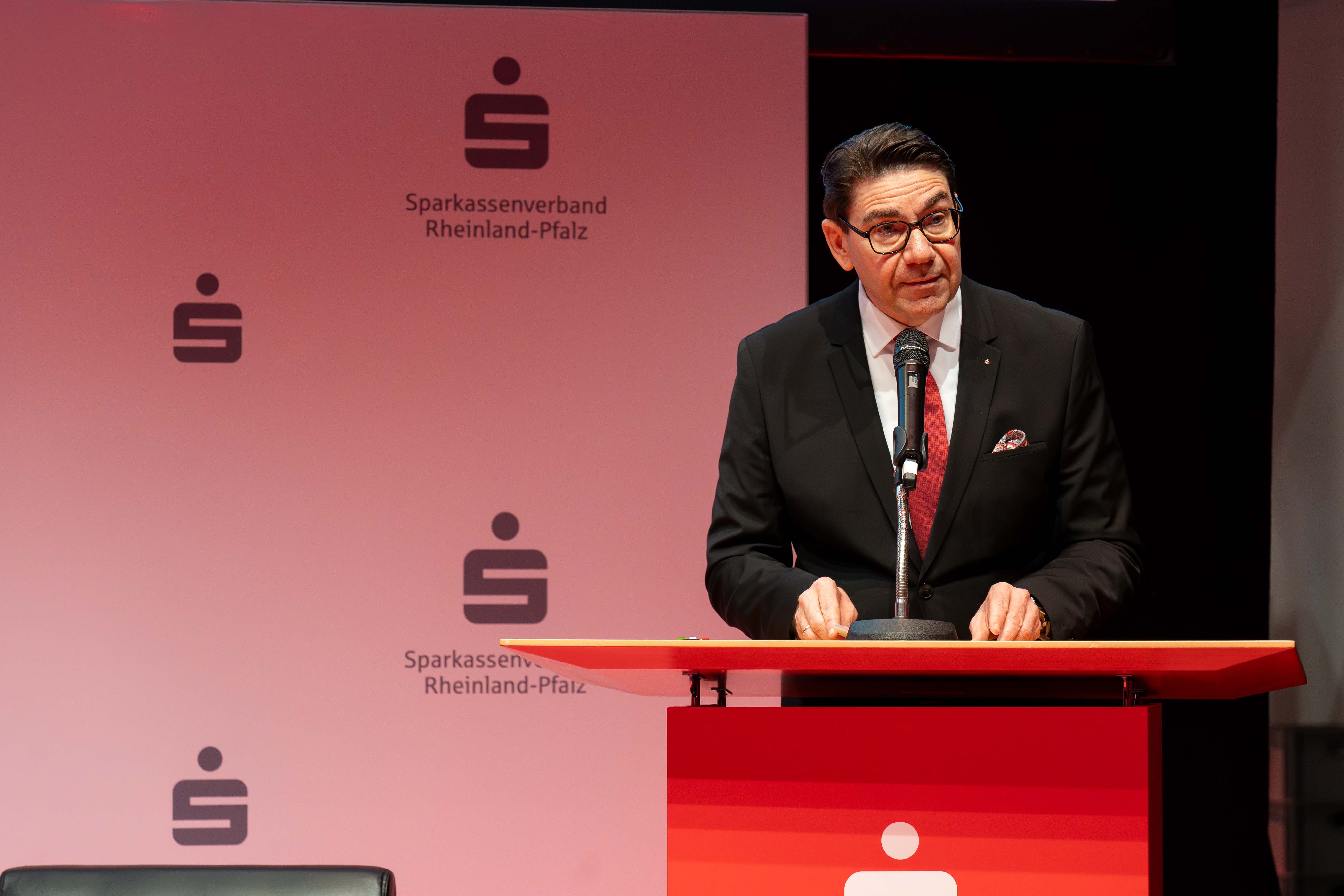 Sparkassenverbandspräsident Thomas Hirsch steht am Rednerpult und spricht zu den Anwesenden.