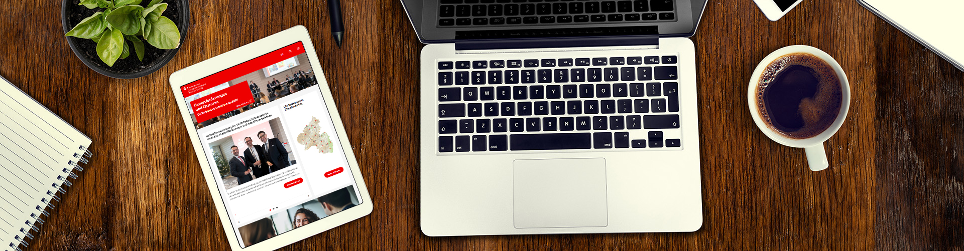  	Blick von oben auf einen Schreibtisch mit einem Tablet, einem Notebook und einer Kaffeetasse