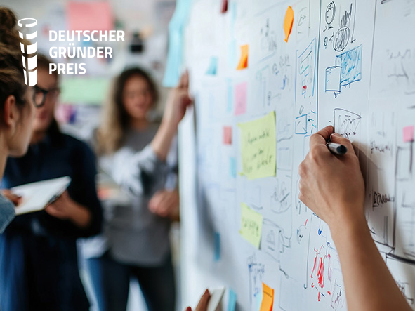 Gruppe junger Menschen, die gemeinsam an einer beschrifteten Metawand stehen