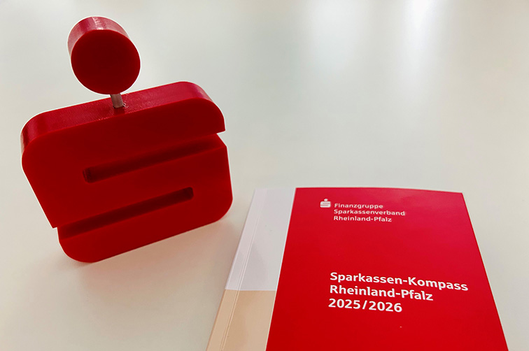 Der Sparkassen-Kompass Rheinland-Pfalz 2025/2026 steht neben einem Sparkassen-Logo-Aufsteller.