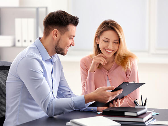 Mann und Frau sitzen mit Tablet am Tisch